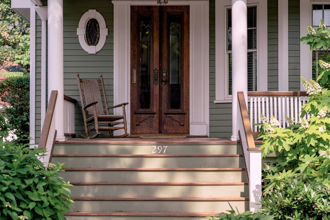 Beautifully styled front porch with natural doormat and potted plants