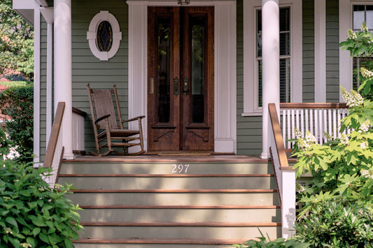 Beautifully styled front porch with natural doormat and potted plants