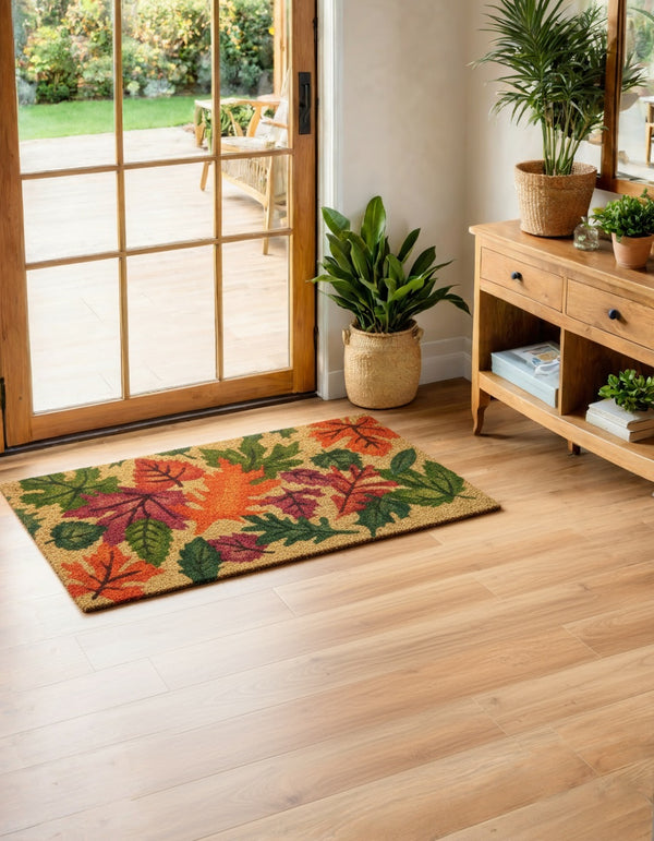 Decorative doormat with autumn leaves on a wooden floor in a home setting.