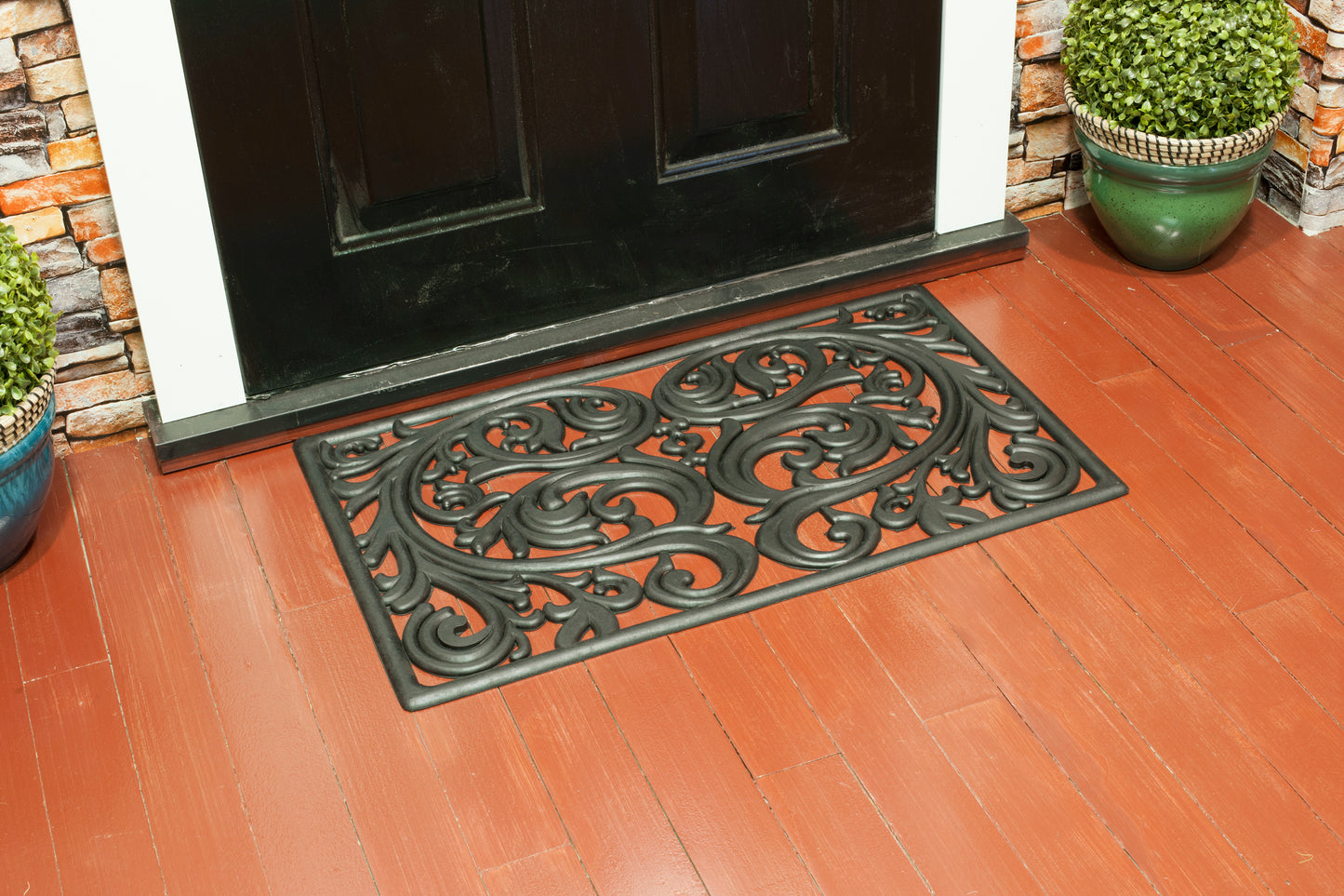 black rubber door mat with decorative filigree scroll pattern