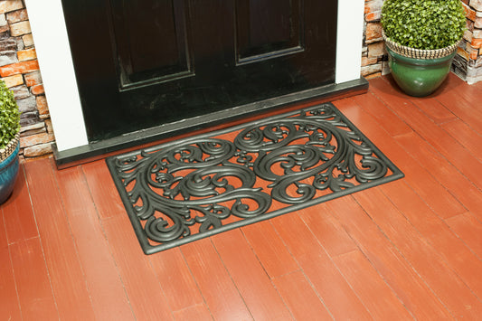 black rubber door mat with decorative filigree scroll pattern
