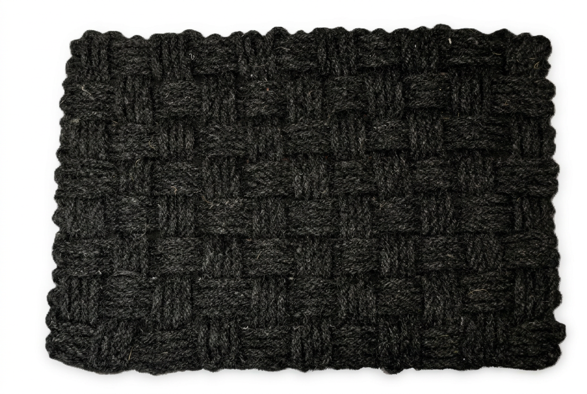 Black handwoven coir basket-weave doormat on a white background