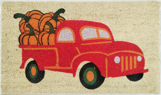 Doormat with a red truck and pumpkins design on a beige background